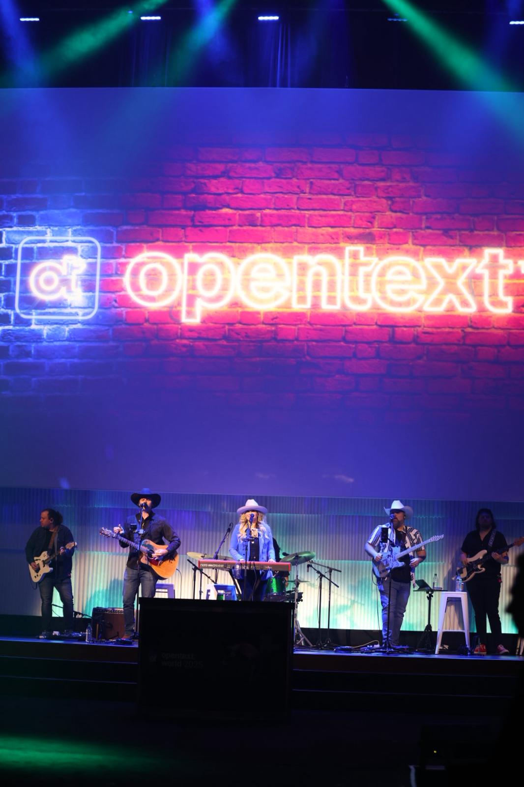 OpenText World 2025 neon OpenText sign and live stage